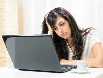 woman slumped over at her laptop