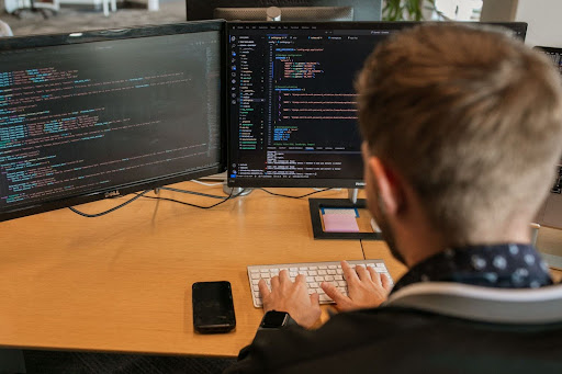 Gemini employee coding on computer.